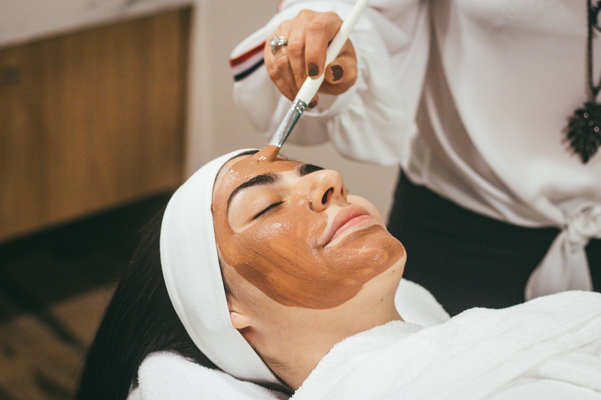 Aplicarea unui tratament de mască facială cosmetică unei paciente